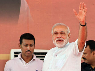 India's opposition Bharatiya Janata Party (BJP) leader and Gujarat state Chief Minister Narendra Modi waves as Olympic silver winning shooter Rajyavardhan Rathore, stands next to him at a political rally in Jaipur, India, Tuesday, Sept. 10, 2013. BJP had earlier appointed Modi to lead its campaign in national elections next year.Rathore joined the BJP Tuesday, local news reports said. AP Photo