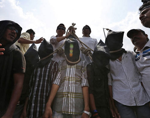 Protesters stage a mock hanging scene to demand death sentence for four men after a judge convicted them in the fatal gang rape of a young woman on a moving New Delhi bus last year, in New Delhi. AP
