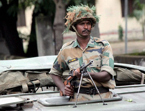 An army trooper during a flag march in the curfew-hit areas in Muzaffarnagar on Sunday. Army was deployed in the curfew clamped area of Muzaffarnagar after communal clashes on Saturday. PTI Photo