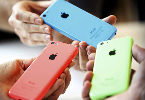 People check out several versions of the new iPhone 5C after Apple Inc's media event in Cupertino, California. REUTERS