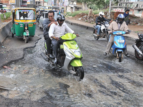 Motorists struggle as sewage water overflows from a  manhole at Ulsoor Road in Bangalore on Thursday.  DH&#8200;Photo/ B K Janardhan
