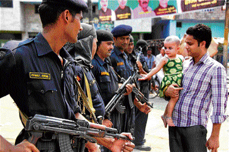 A child plays with security personnel at Khalapar when  curfew was relaxed in Muzaffarnagar on Friday. PTI