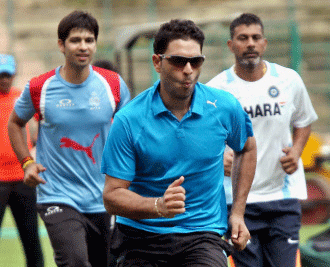 India A captain Yuvraj Singh with Praveen Kumar and Naman Ojha during a practice session in Bengaluru on Friday ahead of the series against West Indies A team. PTI Photo