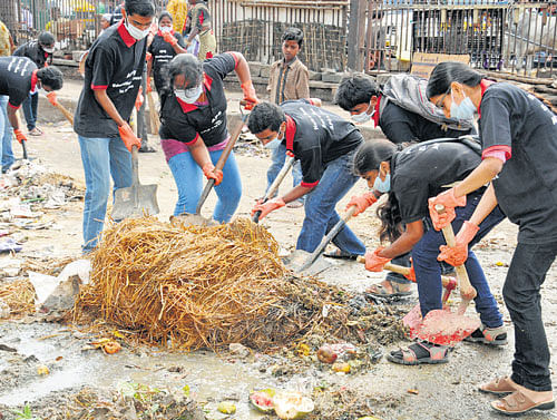 APS College students clearing garbage at KR Market on  Monday.