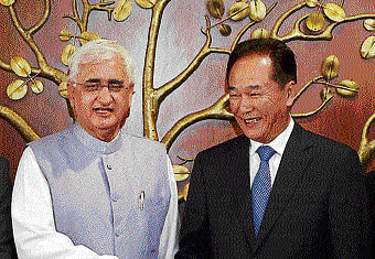 Salman Khurshid shakes hands with China Minister of the State Council Information Office, Cai Mingzhao in New Delhi on Monday. PTI