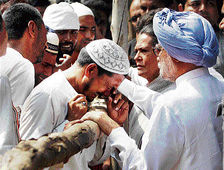 Compassion : Prime Minister Manmohan Singh and Congress president Sonia Gandhi  interact with families of riot victims at Bassi Kalan relief camp in Muzaffarnagar on Monday. PTI