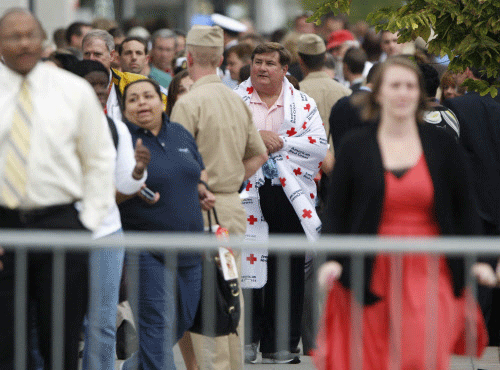 Navy Yard workers, evacuated after a shooting,are reunited with loved ones at a makeshift Red Cross shelter at the Nationals Park baseball stadium near the affected naval installation in Washington, September 16, 2013. A 34-year-old man opened fire at the U.S. Navy Yard on Monday in a shooting that left 13 people dead, including the gunman, not far from the U.S. Capitol and the White House, officials said. The suspect was identified by the FBI as Aaron Alexis of Fort Worth, Texas. Washington D.C. police chief Cathy Lanier told reporters that Alexis 'was engaged in shooting with police officers' when he died. REUTERS