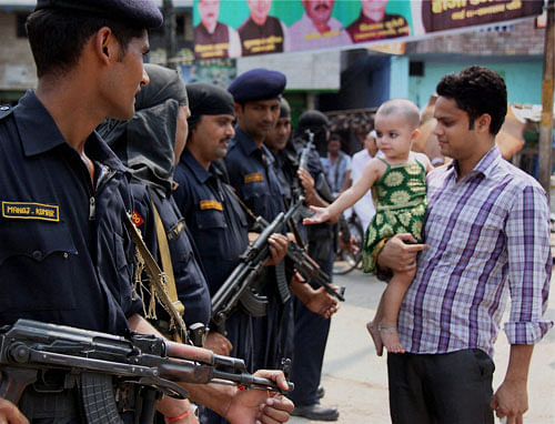 A kid amuses security jawans at Khalapar as the curfew relaxed in Muzaffarnagar. PTI Photo