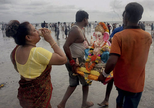 Devotees carry Lord Ganesha's idol for immersion after seven days of Ganeshotsav celebrations in Mumbai on Sunday. PTI Photo