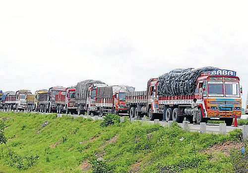 crawling forward: More than 500 trucks were stranded in traffic after rain left massive potholes on the Raichur-Mansalapura highway on Wednesday. dh photo