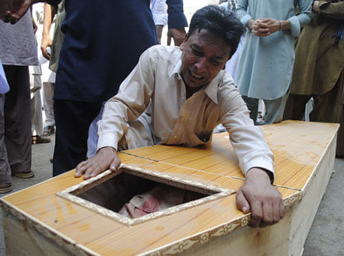 Christian man cries next to the coffin of his relative, who was killed in a suicide blast at a church, at a hospital in Peshawar September 22, 2013. A pair of suicide bombers blew themselves up outside the church in the Pakistani city of Peshawar, killing 60 people after Sunday mass, security officials said. REUTERS