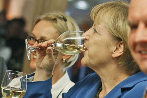 German Chancellor Angela Merkel, chairwoman of the Christian Democratic party CDU drinks a glass of withe wine at the party headquarters after the national elections in Berlin Sunday, Sept. 22, 2013. Chancellor Angela Merkel's conservatives triumphed in Germany's election Sunday, and could even win the first single party majority in more than 50 years. Her center-right coalition partners risked ejection from parliament for the first time in their post-World War II history.(AP Photo/Markus Schreiber)