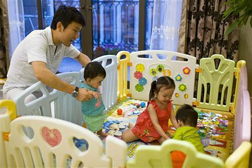 Tony Jiang poses with his three children at his house in Shanghai September 16, 2013. In December 2010, REUTERS