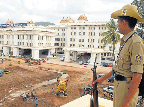 A policeman on a vigil near the new building of JSS in Mysore on the eve of  President Pranab Mukherjee's visit, on Sunday. DH PHOTO