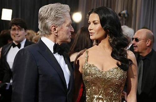 Actor Michael Douglas talks with his wife, actress Catherine Zeta-Jones, at the 85th Academy Awards in Hollywood, California February 24, 2013 file photo.