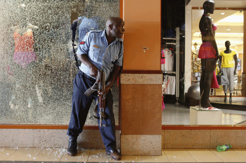 A police officer tries to secure an area inside the Westgate Shopping Centre where gunmen went on a shooting spree in Nairobi September 21, 2013. The gunmen stormed the shopping mall in Nairobi on Saturday killing at least 20 people in what Kenya's government said could be a terrorist attack, and sending scores fleeing into shops, a cinema and onto the streets in search of safety. Sporadic gun shots could be heard hours after the assault started as soldiers surrounded the mall and police and soldiers combed the building, hunting down the attackers shop by shop. Some local television stations reported hostages had been taken, but there was no official confirmation. REUTERS