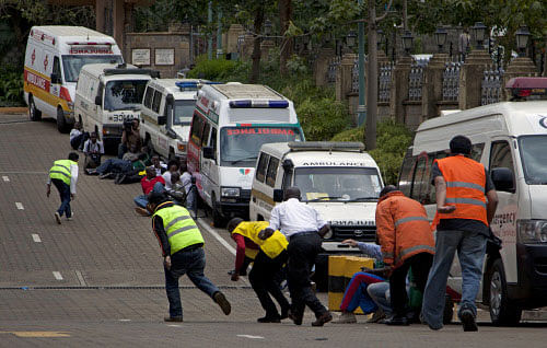 Paramedics run beside parked ambulances outside the Westgate Mall in Nairobi after heavy shooting started for the third time since the morning Monday, Sept. 23, 2013. Kenya's military launched a major operation at the upscale Nairobi mall and said it had rescued 'most' of the hostages being held captive by al-Qaida-linked militants during the standoff. (AP Photo