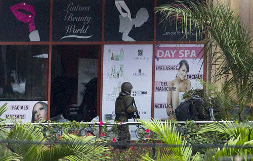 A Kenyan soldier prepares to enter the Westgate Mall, following a bout of heavy gunfire just after dawn, in Nairobi, Kenya Tuesday, Sept. 24, 2013. Kenyan security forces battled al-Qaida-linked terrorists in an upscale mall for a fourth day Tuesday in what they said was a final push to rescue the last few hostages in a siege that has left at least 62 people dead. (AP Photo