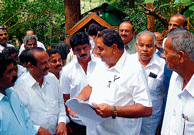 Minister for Forest and Ecology Ramanath Rai receives petition from Basavanahalli residents in Kushalnagar, on Tuesday. DH&#8200;Photo