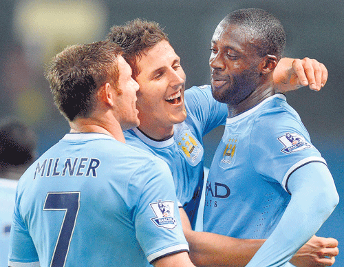 elated: Manchester City's Yaya Toure (right) is all smiles  after scoring his team's third goal against Wigan Athletic. afp