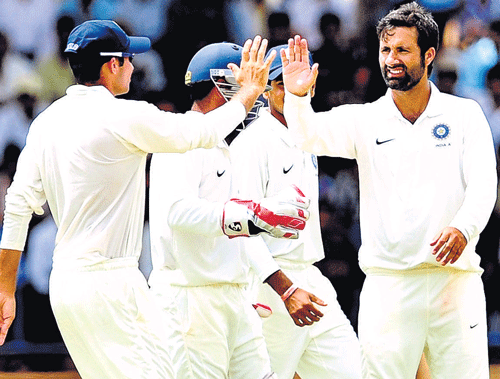high five: Parvez Rasool (right) celebrates after snaring a West Indies wicket on the second day of the four-day match in Mysore on Thursday. dh photo/ satish badiger