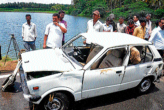 miracle: People curiously watch the car that plunged into Shetty lake (Mandakalli) in Mysore on Thursday. DH Photo