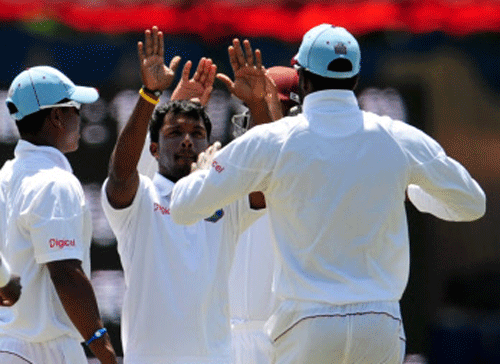 West Indies A team bowler Permaul Veerasammy celebrates with teammates after dismissing the India A Team Batsman Manpreet Juneja during the 3nd day of 4 Day West Indies A Vs India A 2013 Match at Gangothri Glades in Mysore . Photo