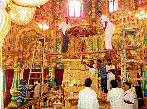 preparations: Workers attached to the office of royal scion Srikantadatta Narasimharaja Wadiyar assemble the Golden Throne, at Mysore Palace, on Sunday.  The throne kept in the strong room was offered puja by palace priest Janardhan. It will be kept open for public viewing at durbar hall from October 2. DH PHOTO