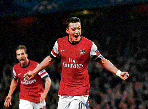 red hot: Arsenal's Mesut Ozil celebrates after scoring against Napoli during their Champions League tie on Tuesday. REUTERS