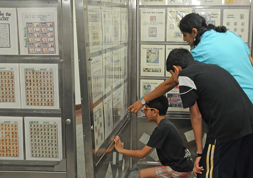 People looking at Mahatma Gandhi stamps during the  'My life is My message' stamps and photographs exhibition organised by Rangoli Metro Art Centre, General Post office and Karnataka Philately Society at Metro Rail Station Boulevard  in Bangalore on Wednesday. DH Photo by S K Dinesh