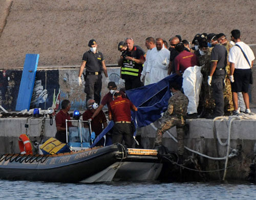 Rescuers lift a body bag as they reach the port of Lampedusa, southern Italy, Thursday, Oct. 3, 2013. At least 114 people died and scores more were missing late Thursday after a crowded fishing boat carrying African migrants from Tripoli caught fire, flipped over and sank, Italian officials said. Between 450 and 500 people were believed to be on board; health commissioner Antonio Candela said only 159 were rescued. AP Photo