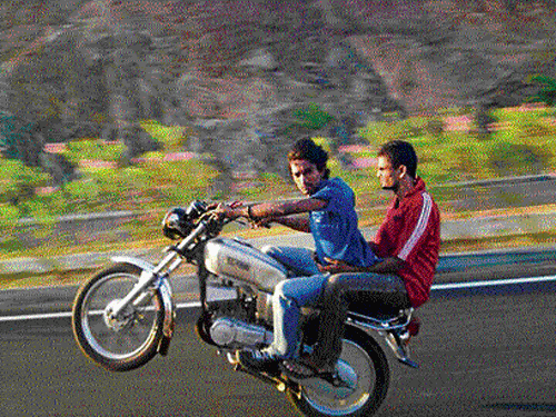 Dangerous: Young boys doing wheelies is a common sight in Bangalore.