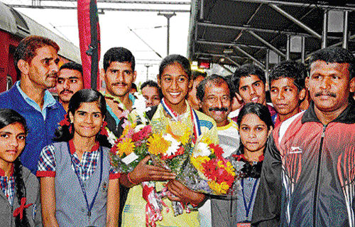 The cynosure: Karnam Twisha (centre), who won the bronze at the Junior Asian Women's Kayaking Championship, gets a big welcome upon arrival in Bangalore. DH photo/ SK DINESH