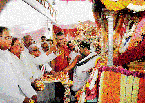 divine moment: &#8200;Litterateur Chandrashekara Kambara offers floral tributes to the idol of&#8200; Goddess Chamundeshwari inside the silver chariot, marking the beginning of Dasara festival at Chamundi Hill, Mysore on Saturday. dh photo