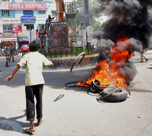 A supporter of United Andhra Pradesh throws a tyre into flames at Tirupati in Chittor district of Andhra Pradesh state 575 kilometers (357 miles) from Hyderabad, Friday, Oct. 4, 2013. The approval for the creation of "Telangana" state set off protests in Seemandhra region of Andhra Pradesh Friday. Telangana would become 29th state. (AP Photo)