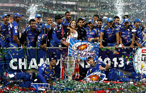 Mumbai Indians players celebrate with trophy after winning final of the CLT20 against Rajasthan Royals at the Ferozshah Kotla stadium in New Delhi on Sunday. PTI Photo