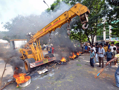 Protesters stop a crane as they block a road with burning tyres during a protest against the creation of Telangana state, at Vizag. Reuters
