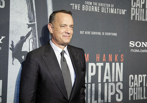 Tom Hanks poses for photographers as he walks the red carpet at a screening for the movie 'Captain Phillips' at the Newseum, Wednesday, Oct. 2, 2013 in Washington. (AP Photo/Alex Brandon)