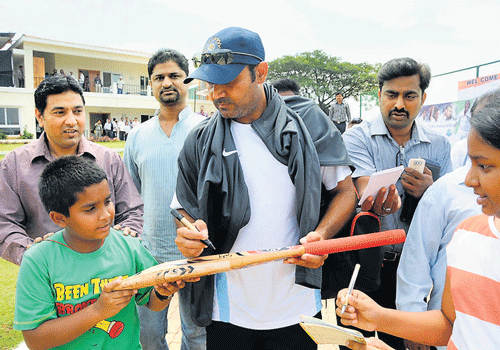 Virender Sehwag obliges autograph hunters. DH Photo