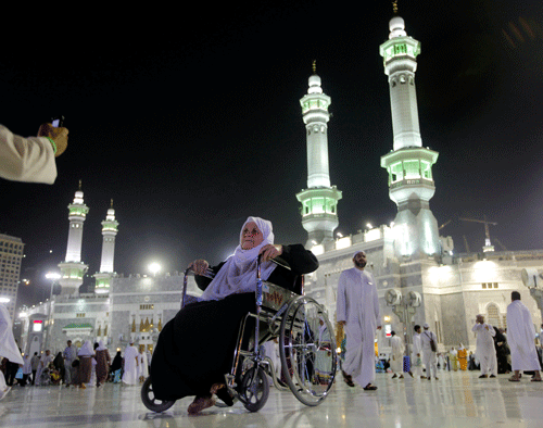 An elderly Muslim pilgrim poses for a picture in front of the Grand Mosque in the holy city of Mecca, Saudi Arabia, late Tuesday, Oct. 8, 2013. AP