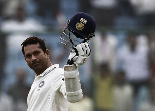 File photo of India's Tendulkar raising his cap in celebration after completing 15,000 runs in his test career during the third day of their first test cricket match against West Indies in New Delhi Reuters
