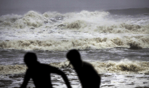 People run for shelter following a cyclone warning at the Bay of Bengal coast in Gopalpur beach in Ganjam district about 200 kilometers (125 miles) from the eastern Indian city Bhubaneswar, India, Saturday, Oct. 12, 2013. Hundreds of thousands of people living along India's eastern coastline were taking shelter Saturday from a massive, powerful cyclone Phailin that was set to reach land packing destructive winds and heavy rains. AP photo