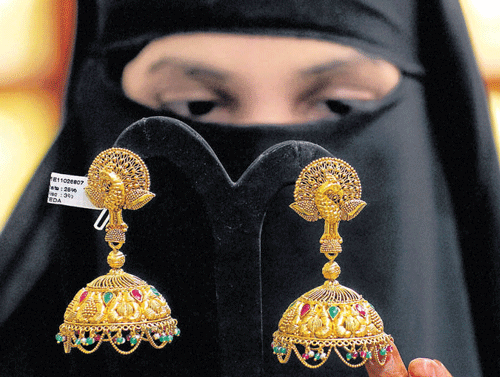 A customer checks out gold jewellery at a showroom in Chennai in this file photo. PTI