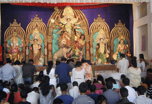 Braving the downpour, people thronged Durga puja pandals to offer their tributes to the goddess on the last day of the five-day festivity. PTI Photo.