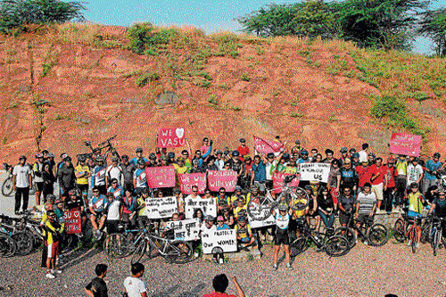 For a cause: Cyclists hold placards to raise awareness regarding safety of women.