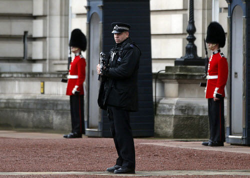 A British police officer guards the grounds of Buckingham Palace in central London, Monday, Oct. 14, 2013. British police arrested a man with a knife after he tried to dart through a gate at Buckingham Palace in London on Monday. The palace said Queen Elizabeth II was not in residence. Breaches of royal security are rare, but just a month ago police arrested two men over a suspected break-in at the palace. AP photo