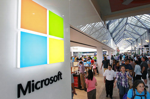 FILE - In this Thursday, Aug. 23, 2012, file photo, a new Microsoft Corp. logo, left, is seen on an exterior wall of a new Microsoft store inside the Prudential Center mall, in Boston. Microsoft is updating its Windows software for cellphones to accommodate larger devices and make it easier for motorists to reduce distractions while driving. AP photo
