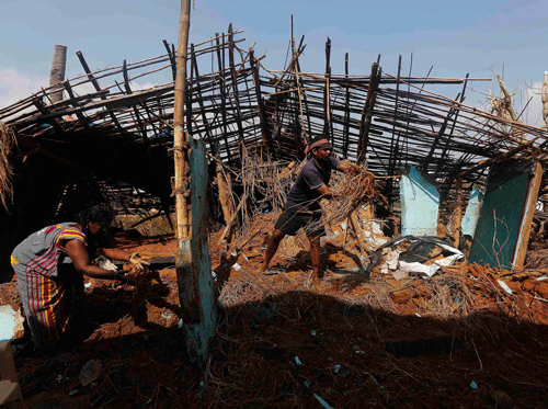 A fisherman and his wife clear the debris from their damaged house after Cyclone Phailin hit Gopalpur village in Ganjam district in the eastern Indian state of Odisha October 14, 2013. A mass evacuation saved thousands of people from India's fiercest cyclone in 14 years, but aid workers warned a million would need help after their homes and livelihoods were destroyed. Cyclone Phailin was expected to dissipate within 36 hours, losing momentum on Sunday as it headed inland after making landfall from the Bay of Bengal, bringing winds of more than 200 kph (125 mph) that ripped apart tens of thousands of thatched huts, mangled power lines and tore down trees. REUTERS