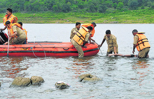 Tragic end: Rescuers search for the bodies of four persons from Bangalore, who drowned in the backwaters of  Manchanabele dam near Magadi, on Monday. Inset: Ashok and Mohan, two of the victims. KPN