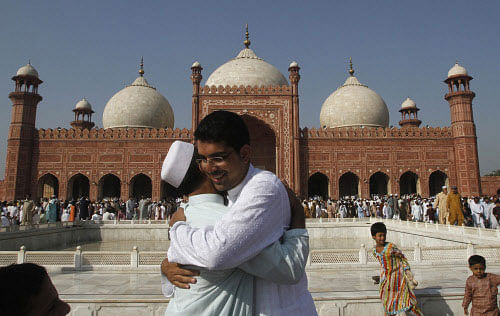 Pakistani Muslims greet each other after attending a prayer session during the annual festival of Eid al-Adha, or the Festival of Sacrifice, in Lahore